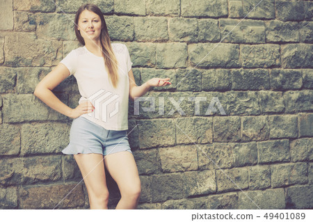 Young woman on old stone wall background Young woman on old stone wall background 49401089