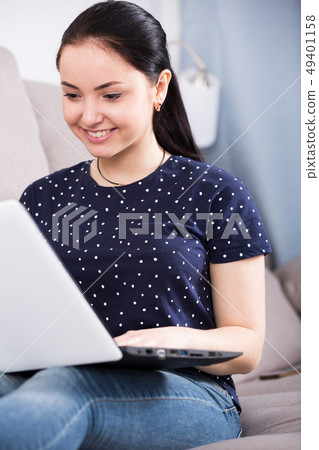 Young woman with laptop on sofa 49401158