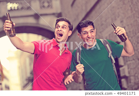 Two adult male are satisfied of win of their football teem Two adult male are satisfied of win of their football teem 49401171