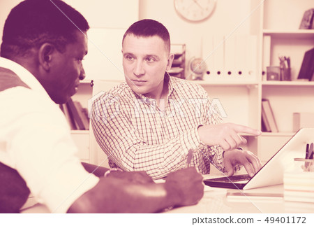 Two businessmen working in the office at the laptop Two businessmen working in the office at the laptop 49401172