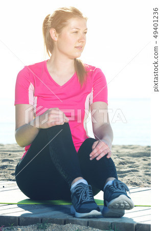 Woman resting after training on beach 49401236
