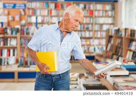 elderly man customer visiting bookshop in search of interesting fiction elderly man customer visiting bookshop in search of interesting fiction 49401419