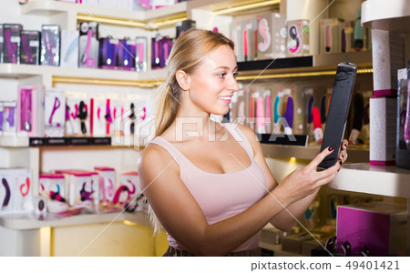 adult girl choosing toys in sex shop. adult girl choosing toys in sex shop. 49401421