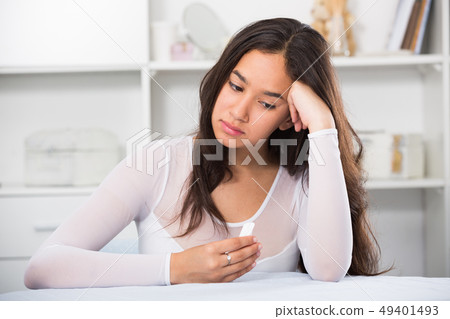 Young sad woman sitting at the table Young sad woman sitting at the table 49401493