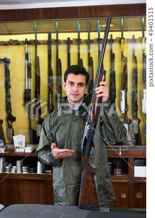 Portrait of cheerful confident man showing rifle Portrait of cheerful confident man showing rifle 49401515