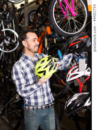 Sport racer is choosing for himself comfortable helmet Sport racer is choosing for himself comfortable helmet 49401754