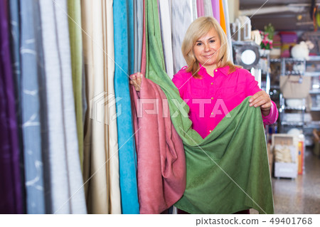 Mature female choosing curtains in the curtains shop Mature female choosing curtains in the curtains shop 49401768