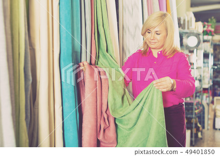 Mature female choosing curtains in the curtains shop Mature female choosing curtains in the curtains shop 49401850
