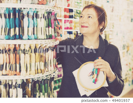 Woman choosing mouline for embroidery in needlework shop Woman choosing mouline for embroidery in needlework shop 49401937