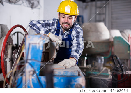 Adult guy is using disk saw to cut tile 49402084