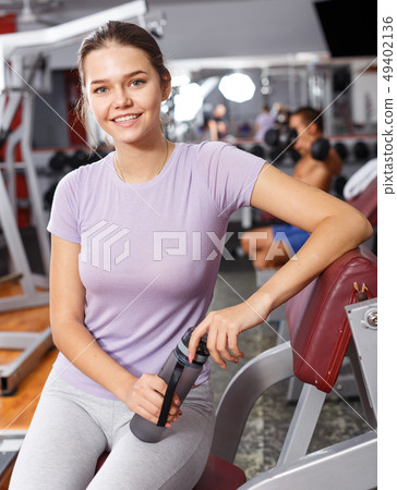 Woman posing among sports equipment Woman posing among sports equipment 49402136