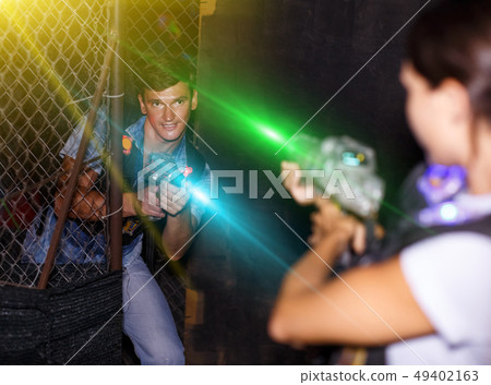 couple holding colored laser guns during laser tag game 49402163