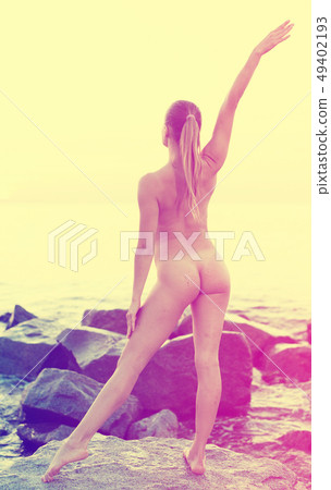 naked female doing exercises at sunset sea shore naked female doing exercises at sunset sea shore 49402193