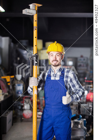 Positive guy worker erecting framing at workshop Positive guy worker erecting framing at workshop 49402327