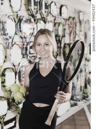 balls and a tennis racket in a sporting store balls and a tennis racket in a sporting store 49402437