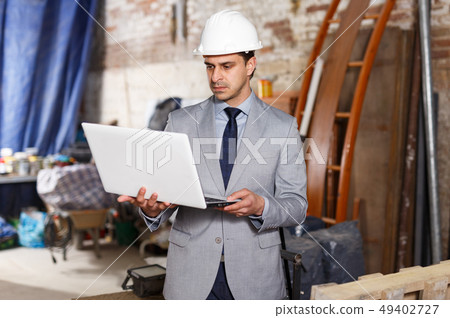 Manager using laptop with blueprints Manager using laptop with blueprints 49402727