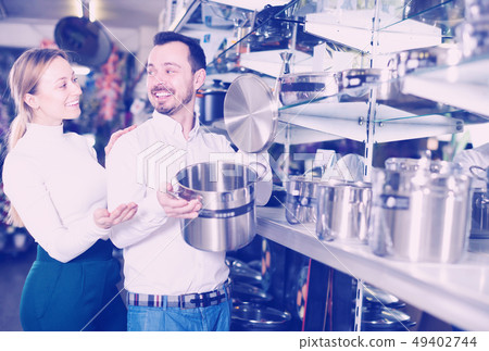 Cheerful loving couple deciding on best saucepan 49402744