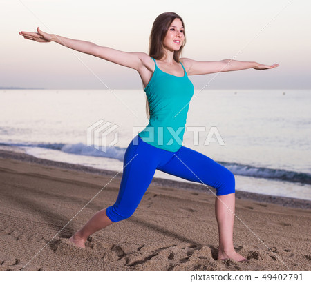 Smiling young woman in blue T-shirt is doing excercises on endurance 49402791