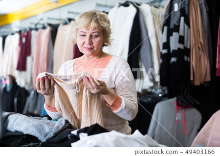 Mature woman choosing color pullover 49403166