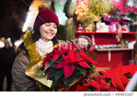 Girl buying floral compositions at Christmas market 49403167