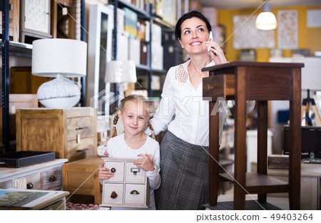Woman with girl in furniture store Woman with girl in furniture store 49403264