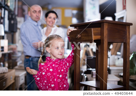 Smilling girl stading with nightstand in furniture store Smilling girl stading with nightstand in furniture store 49403644