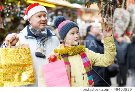 Girl with father choosing Xmas decoration Girl with father choosing Xmas decoration 49403839