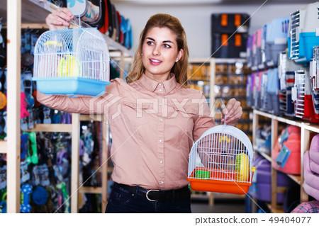Woman choosing pets cage 49404077