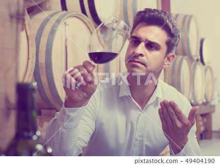 man tasting wine in cellar 49404190