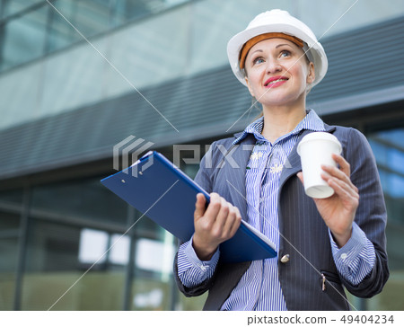 Professional woman in helmet working Professional woman in helmet working 49404234