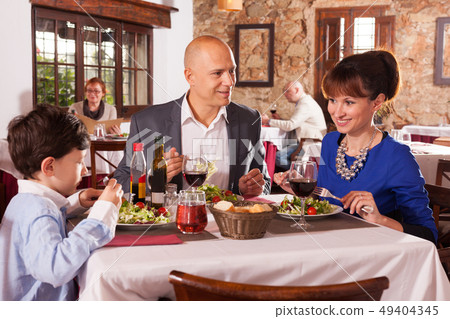 Happy family having dinner Happy family having dinner 49404345
