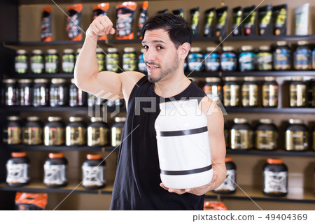 Happy muscular man showing his biceps Happy muscular man showing his biceps 49404369