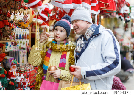 Girl with father shopping on Christmas market Girl with father shopping on Christmas market 49404371