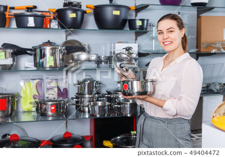 Attractive adult woman is buying new stewpot for kitchen in tableware shop 49404472