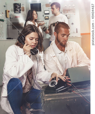 Girl and guy checking telephone set in escape room Girl and guy checking telephone set in escape room 49404487