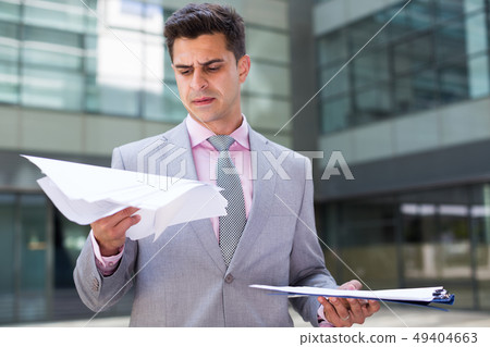 Businessman attentively reading documents 49404663