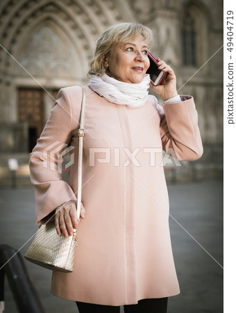 mature female tourist talking on phone mature female tourist talking on phone 49404719