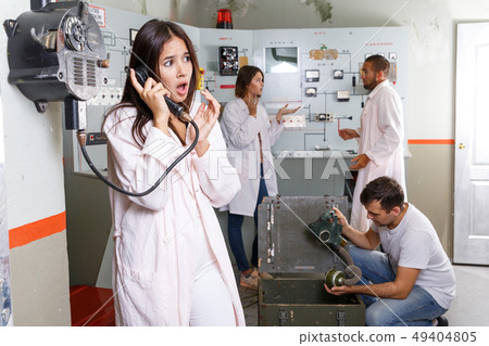 Young woman talking on telephone in lost room-bunker Young woman talking on telephone in lost room-bunker 49404805