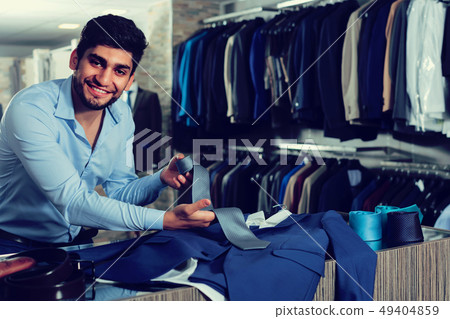 Young guy is showing jacket and tie that he chose Young guy is showing jacket and tie that he chose 49404859