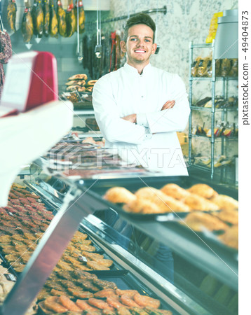 Assistant in grocery shop greeting customers Assistant in grocery shop greeting customers 49404873