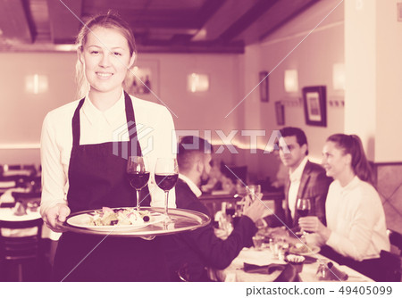 Smiling waitress with serving tray Smiling waitress with serving tray 49405099