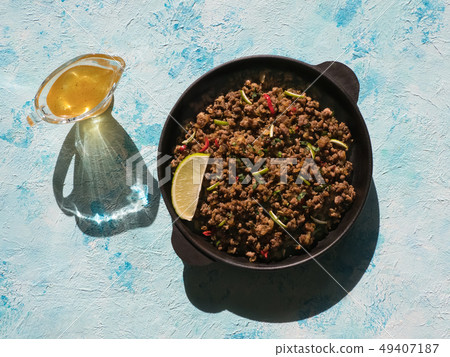 Indian minced meat Qeema on a sunny blue table. Indian minced meat Qeema on a sunny blue table. 49407187