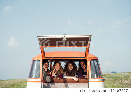 A group of young friends on a roadtrip through countryside, looking out of window. A group of young friends on a roadtrip through countryside, looking out of window. 49407327