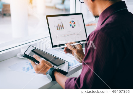 Investors man holding pen pointing tablet to Investors man holding pen pointing tablet to 49407595