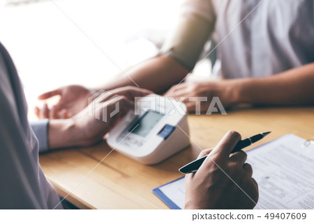 Doctor is using a pulse meter to measure the Doctor is using a pulse meter to measure the 49407609
