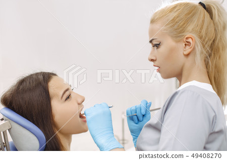 Surprised dentist looking at patient mouth Surprised dentist looking at patient mouth 49408270