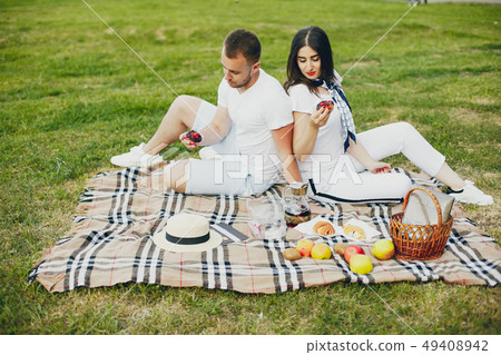 Beautiful couple spend time in a summer park Beautiful couple spend time in a summer park 49408942
