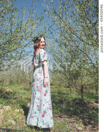 Young beautiful woman in spring blossom trees. 49408946
