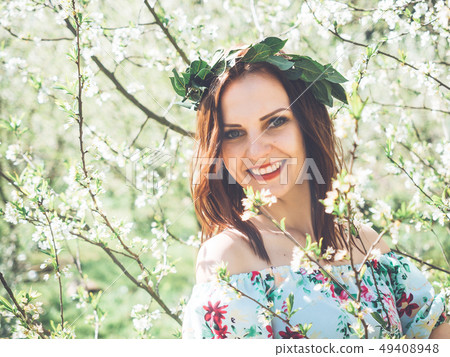 Young beautiful smiling woman in spring blossom Young beautiful smiling woman in spring blossom 49408948