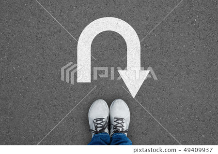 White shoes standing at the u turn sign White shoes standing at the u turn sign 49409937